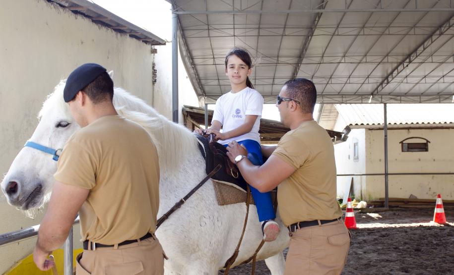 Projeto de equoterapia da Policia Militar Montada do Paraná. Na foto: Maria Eduarda Ramos. sendo auxiliada pelo fisioterapeuta Geter Kleink.  Curitiba, 16-09-2015. Foto: Adrieli Takiguti /SEDS